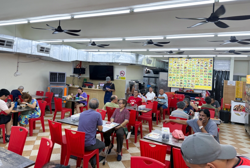 
Tables and chairs are arranged in rows in this corner coffee shop. — Picture by Lee Khang Yi
