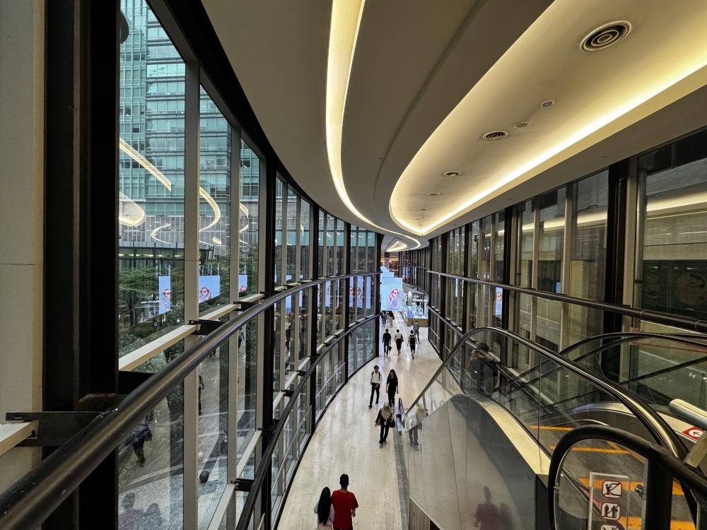 People walk along the indoor bridge connecting Mid Valley Megamall and The Gardens Mall. — Picture by Soo Wern Jun