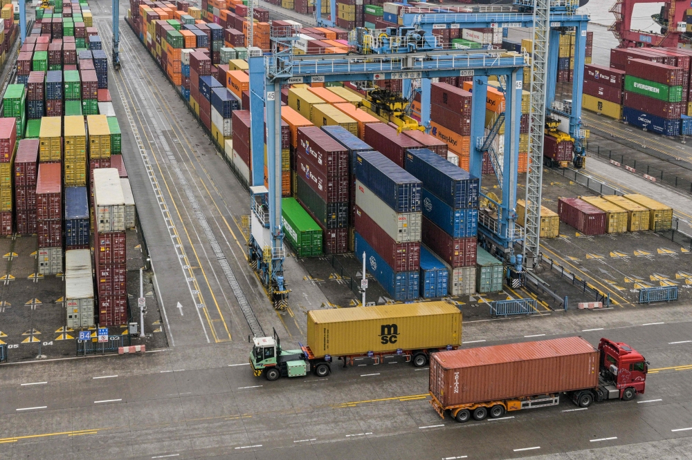 Trucks drive past containers at the Port of Ningbo-Zhoushan in Ningbo, in China's eastern Zhejiang Province on May 28, 2025. — AFP pic