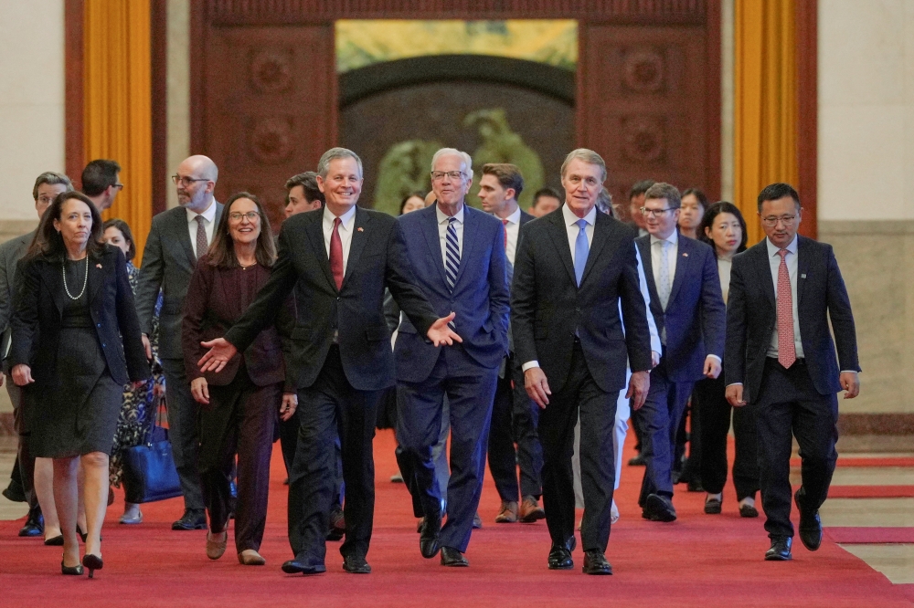 US Senator Steve Daines has a light moment with his congressional delegation on their way to meet with Chinese Premier Li Qiang at the Great Hall of the People, in Beijing May 7, 2026. — Andy Wong/Pool pic via Reuters 