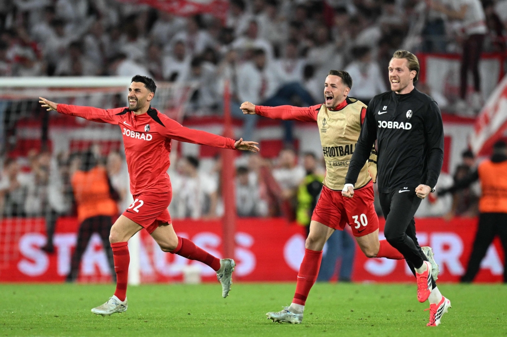 SC Freiburg’s players, Freiburg’s Italian midfielder #32 Vincenzo Grifo, Freiburg’s German defender #30 Christian Guenter and Freiburg’s German goalkeeper #21 Florian Mueller celebrate after winning the Uefa Europa League semi-final second leg football match between SC Freiburg and SC Braga in Freiburg im Breisgau, southwestern Germany May 7, 2026. — AFP pic