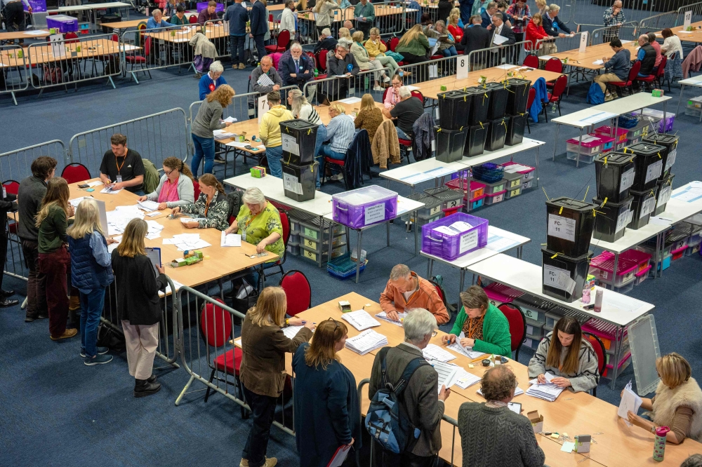 Staff count votes on ballot papers the morning after local elections at a vote-counting centre in Llandudno, north Wales May 8, 2026. — Reuters pic