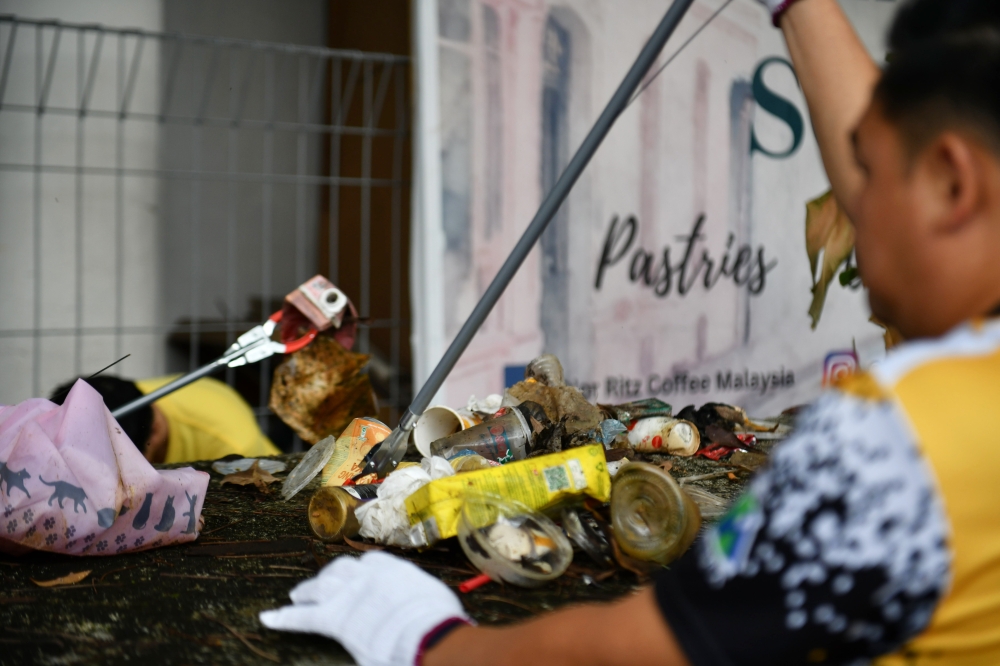 Kuching Trash Hero volunteers work together to collect rubbish around the Kuching Riverbank after it became a weekly mission to ensure the city is clean when met by Bernama recently. — Bernama pic