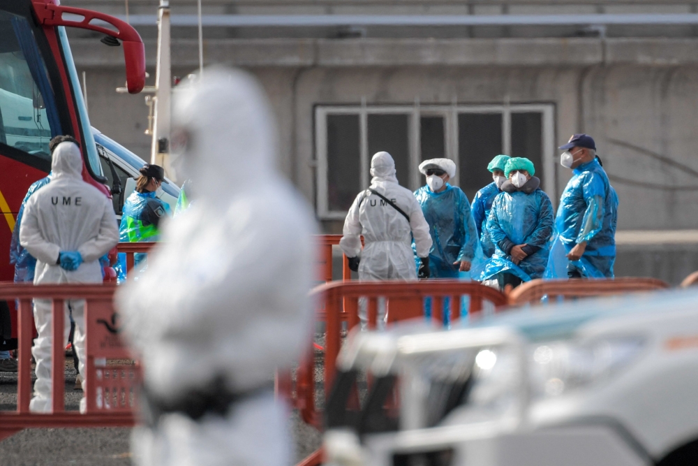 Passengers wearing a blue protective suits board a military bus after being evacuated from the Dutch flagged hantavirus-stricken cruise ship MV Hondius at the industrial port of Granadilla de Abona on the island of Tenerife in Spain's Canary Islands on May 10, 2026. — AFP pic 