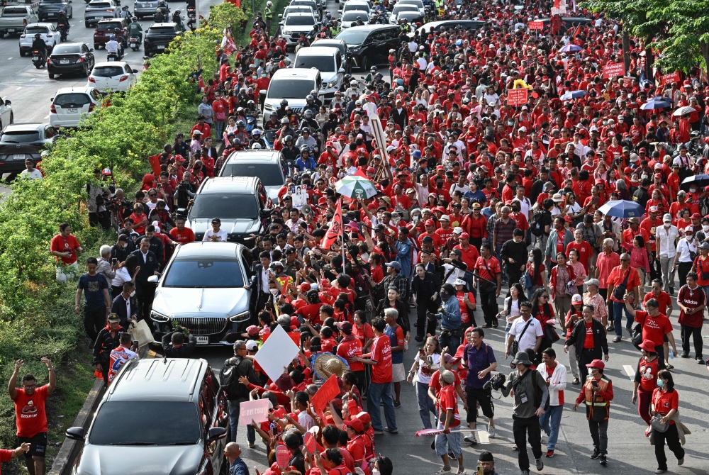 Supporters of Thailand's former prime minister Thaksin Shinawatra gather around his car as he leaves after his release from Klong Prem Central Prison in Bangkok on May 11, 2026. — AFP pic