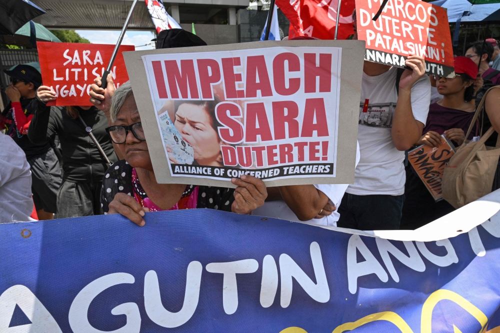 Protesters from progressive groups hold placards during a protest in support of the impeachment of Philippine Vice-President Sara Duterte in front of the Congress building in Quezon City, Metro Manila on May 11, 2026. — AFP pic