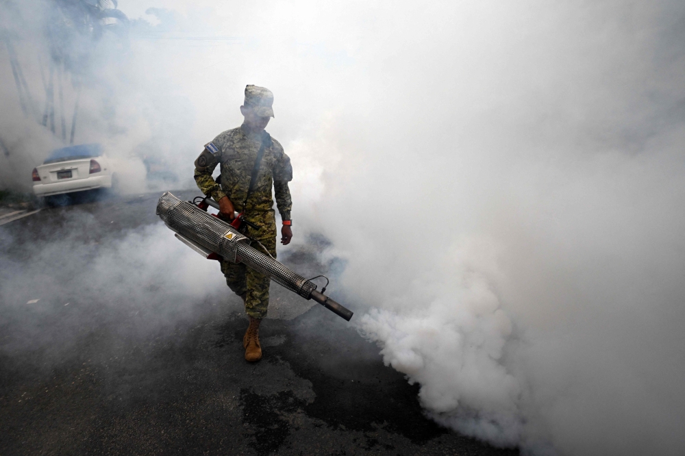 A soldier sprays insecticide to combat Aedes aegypti mosquitoes in a house in San Salvador on October 9, 2024. — AFP pic
