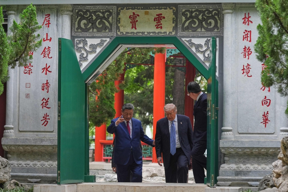 US President Donald Trump walks with Chinese President Xi Jinping at the Zhongnanhai leadership compound in Beijing on May 15, 2026. — AFP pic