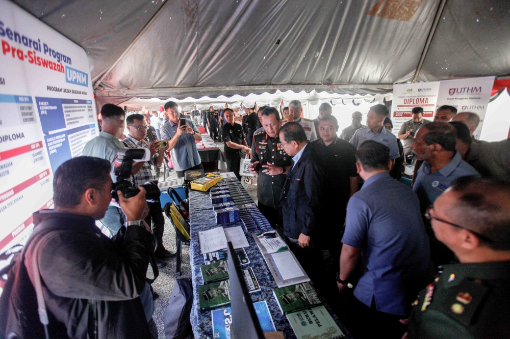 Defence Minister Datuk Seri Mohamed Khaled Nordin visiting a Universiti Pertahanan Nasional Malaysia (UPNM) booth, accompanied by National Defence University Malaysia Vice-Chancellor Datuk Seri Arman Rumaizi (left), after the launch of the Work-Based Learning 2.0 programme at Terendak Camp, Sungai Udang, Melaka. 