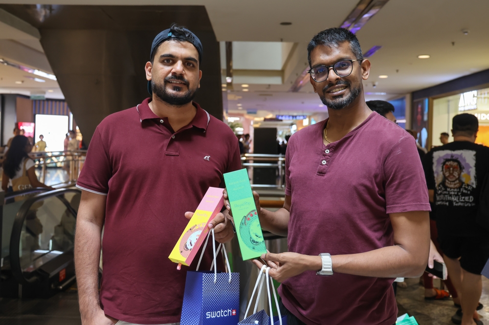 Ammanjit Singh, 39 (left) poses for pictures with his friend after buying the Swatch X Audemars Piguet Royal Pop watches at Mid Valley Megamall in Kuala Lumpur on May 16, 2026. — Picture by Yusof Isa