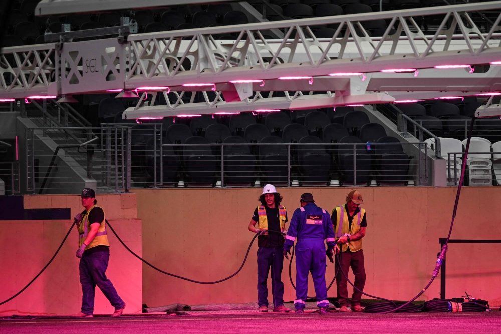 Workers are seen at Dallas Stadium (temporarily renamed from AT&T Stadium for the 2026 FIFA World Cup) with purple lights illuminating the field to promote grass growth, in Arlington, Texas, on May 14, 2026. — AFP pic