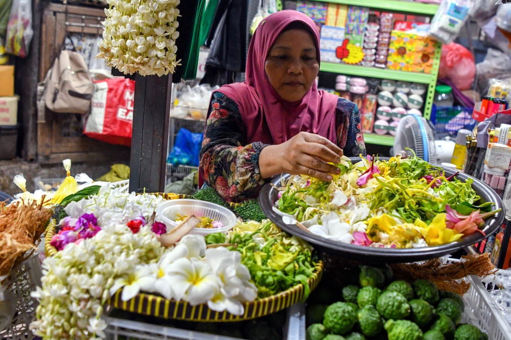 Vendor Mazura Mat Jusoh said demand for traditional flower bath ingredients rises during school holidays and festive seasons at Pasar Siti Khadijah. — Bernama pic