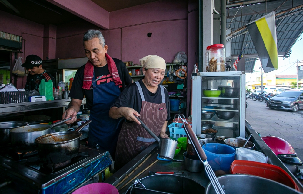 Nur Misha Yoon Abdullah prepares Chinese-style noodle dishes at RM Corner, the family-run halal eatery she operates with her husband that has become known as a multicultural gathering spot. — Bernama pic