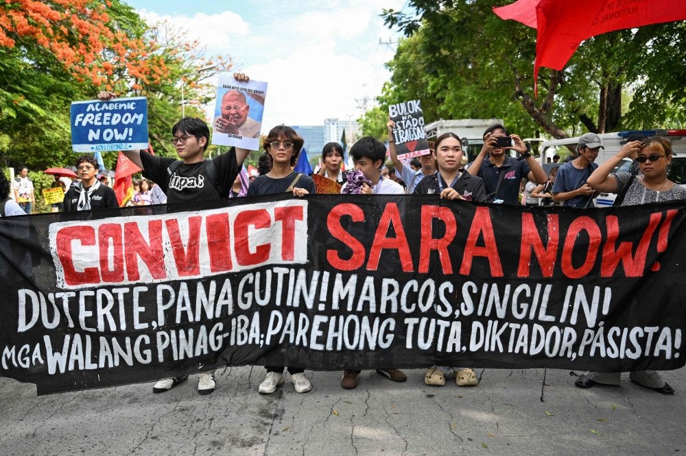 Protesters hold a banner during a demonstration to call for the start of the impeachment trial against Philippine Vice-President Sara Duterte and the arrest of Philippine Senator Ronald ‘Bato’ Dela Rosa outside the Senate of the Philippines in Pasay, Metro Manila on May 18, 2026. — AFP pic