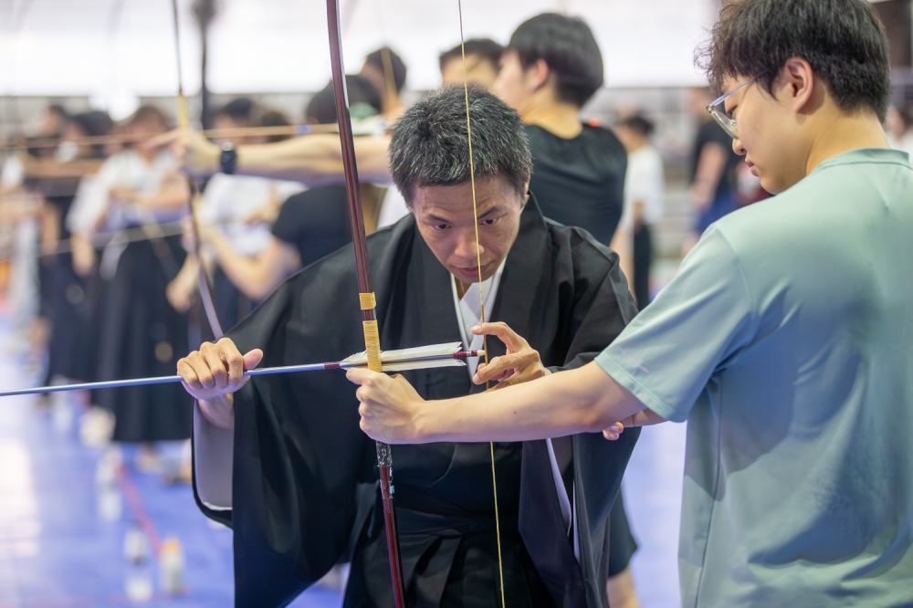 Kyudo practitioner Ng Jim Teng, 41, guides a participant on proper hand placement and grip during a hands‑on martial arts demonstration in Petaling Jaya, May 3, 2026. — Picture by Raymond Manuel