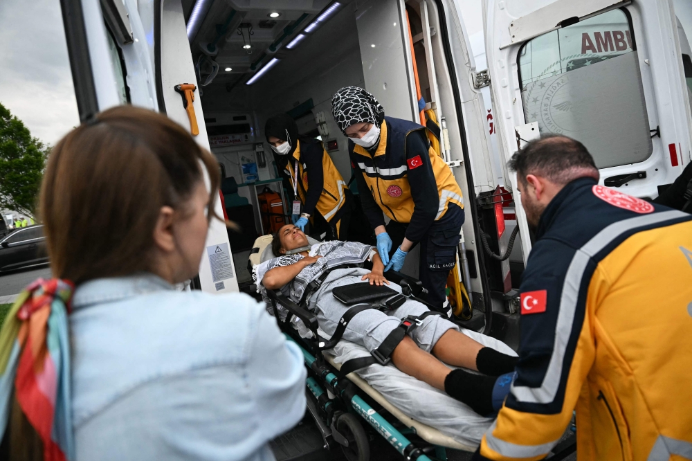 A Global Sumud Flotilla activist deported from Israel is stretchered into an ambulance after arriving at Istanbul Airport on May 21, 2026. — AFP pic