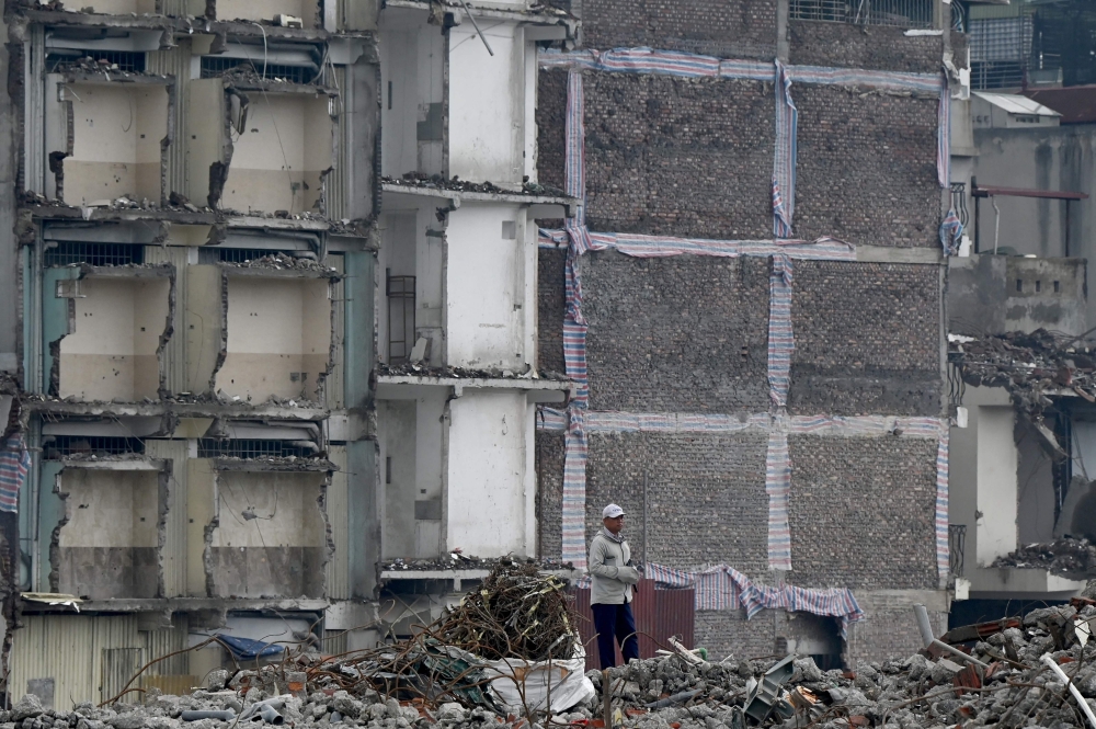 A man looks on at a demolition site of former residential buildings to make way for an expanded road network in Hanoi May 18, 2026. — AFP pic