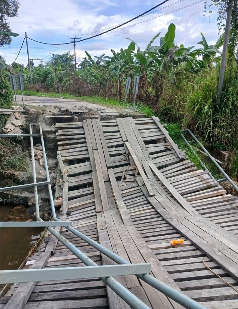 The damaged old wooden bridge. — The Borneo Post pic