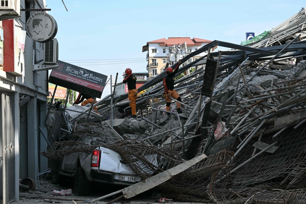 Rescuers stand among the rubbles of a collapsed building in Angeles City, Pampanga province, north of Manila on May 24, 2026. — AFP pic 