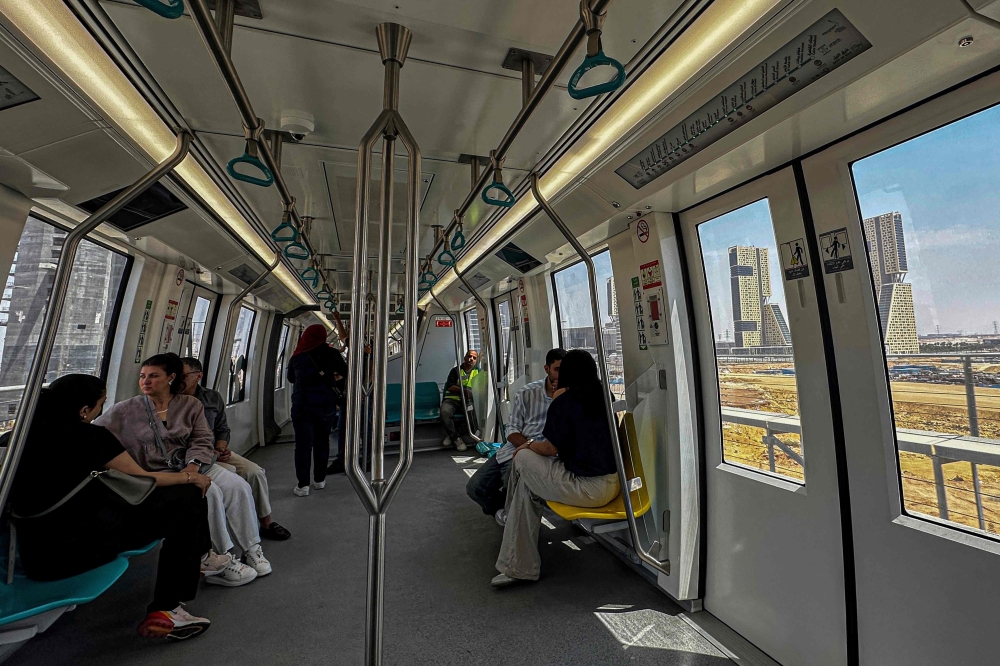 Passengers ride aboard the new Cairo Monorail as it moves through the New Administration Capital (NAC) megaproject, some 45 kilometres east of Cairo, on May 22, 2026. Cairo's new futuristic monorail slices across the city skyline, its sleek carriages gliding above honking cars, the exhaust of aging buses and the familiar chaos of rush hour in the megalopolis. The $4.5 billion two-line network, about seven years in the making, is a flagship of the Egyption president's administration, in office since 2015. — AFP pic