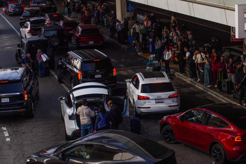 People wait for their ride and cars stop to pick up travellers at the arrival area of Los Angeles International Airport (LAX) in Los Angeles, California, on May 15, 2026. — AFP pic