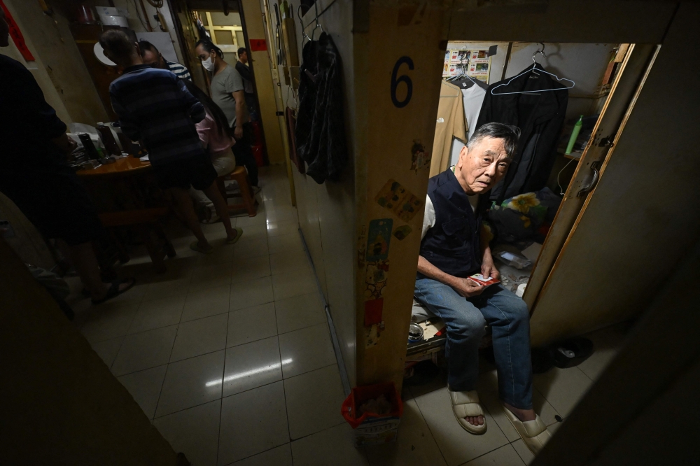 This photo taken on May 4, 2026 shows an unidentified man looking out of his so-called ‘cage home’ in a subdivided housing unit in Kowloon, Hong Kong. — AFP pic