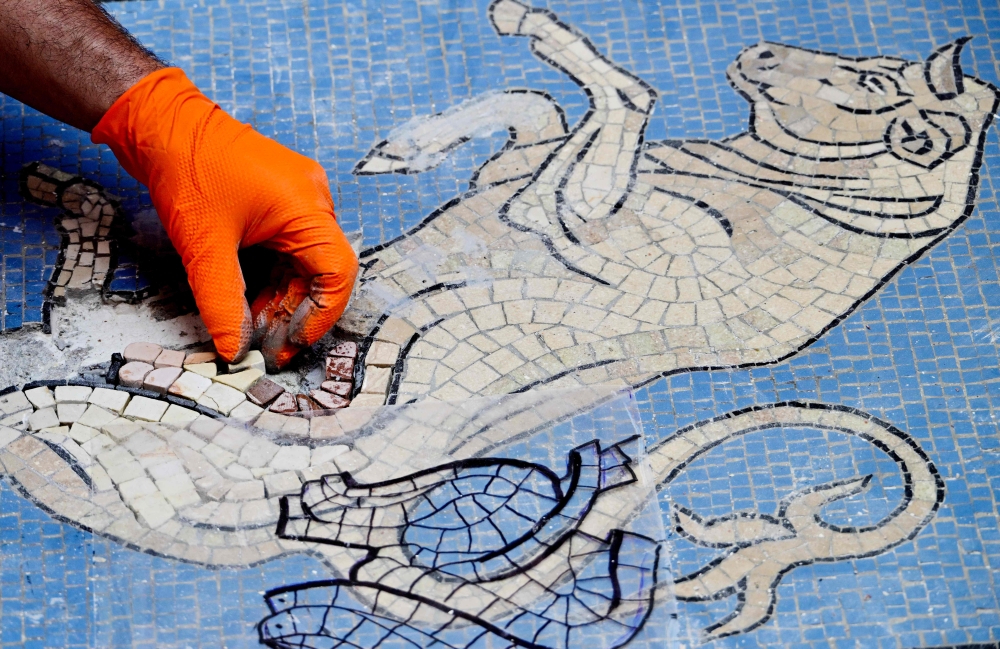 Restorer Gianluca Galli works on the bull mosaic during restoration at Milan’s Galleria Vittorio Emanuele II on May 28, 2026. — AFP pic