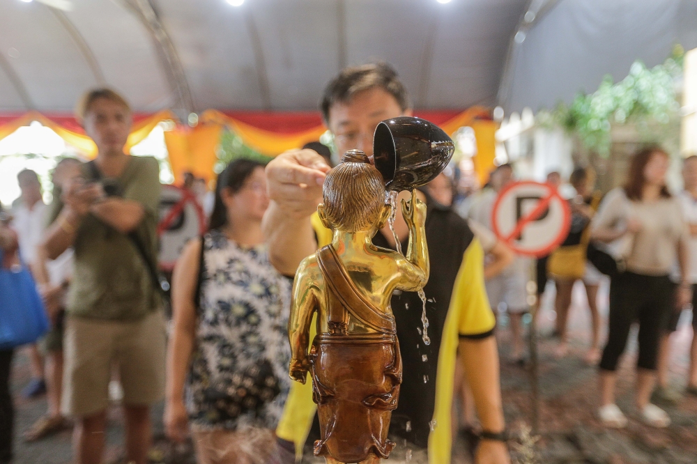 A devotee performs the infant Buddha bathing ritual during Wesak Day celebrations at the Thai Buddhist Chetawan Temple, Petaling Jaya. — Picture by Sayuti Zainudin