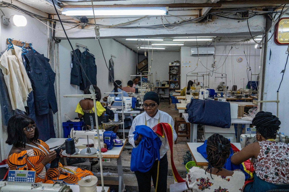 A worker carries fabric at the Okasol workshop in Kinshasa on May 18, 2026. Sewing machines whirred across bold fabrics at a Kinshasa atelier where Congolese tailors and their style-savvy customers have revived a suit long associated with life under a dictator. — AFP pic