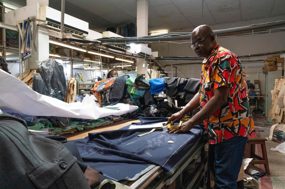 A tailor cuts fabric at the Okasol workshop in Kinshasa May 18, 2026. — AFP pic