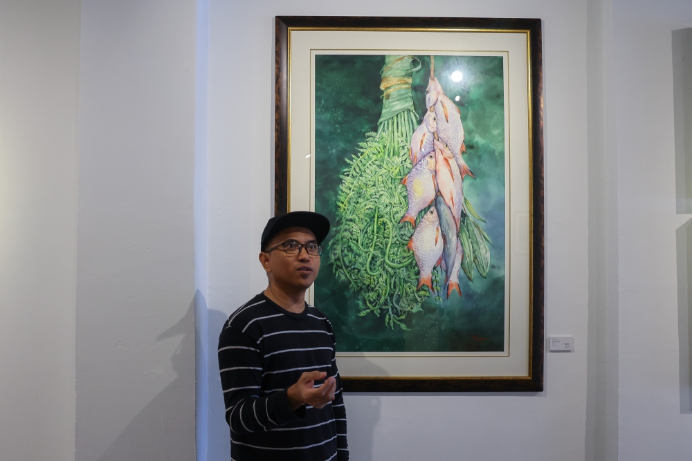 Ryzalman Misran reminiscences on his childhood fishing trips with his brothers in Simpang Renggam that inspired his “Ikan Putih Paku Pakis” portrait. — Picture by Yusof Mat Isa