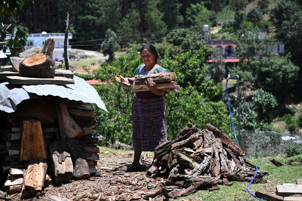 Indigenous woman Cecilia Pasa, 38, loads firewood at her house in the Xetzac community of Cunen, Quiche department, Guatemala, on May 27, 2026. — AFP pic