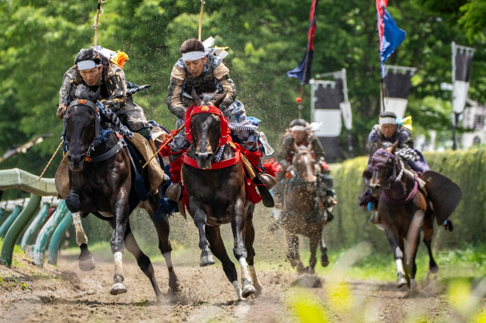 Horsemen clad in samurai armor compete in the Kachu Keiba race during the Soma Nomaoi festival at Hibarigahara field in Minamisoma, Fukushima prefecture on May 24, 2026. — AFP pic