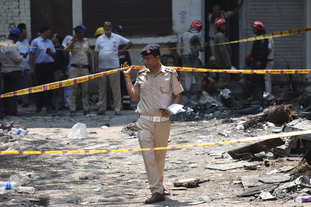 A police officer walks in-between security tapes at the spot after a fire at a hotel in New Delhi June 3, 2026. — Reuters pic  