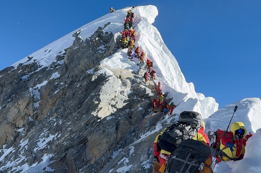 This photograph taken on May 20, 2026, shows mountaineers climbing a slope lined up during their ascent from the Hillary Step to summit Mount Everest in Nepal. 
