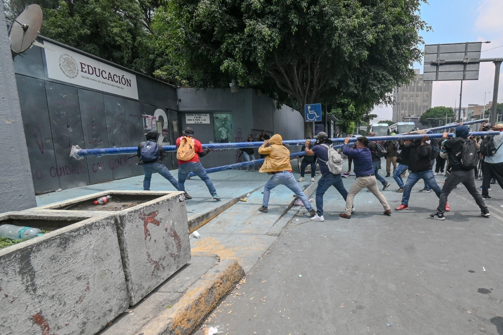 Protesters break into the Ministry of Education during a demonstration by the National Coordination of Education Workers (CNTE) in Mexico City on June 3, 2026. — AFP pic