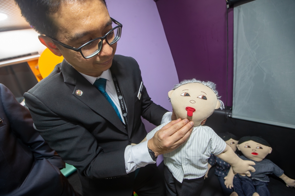 Deputy Registrar Zuhair Rosli demonstrates how the anatomical doll’s retractable tongue works. — Picture by Raymond Manuel