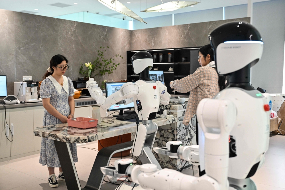 An engineer trains a humanoid robot to do household tasks at the X Square Robot facilities in Shenzhen, southern China’s Guangdong province on May 22, 2026. — AFP pic 