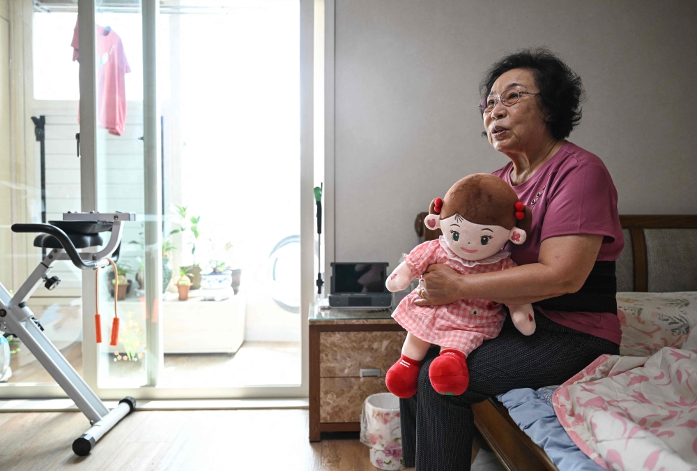 Bang Chun-ja, a South Korean elderly woman living alone, holding Hyodol, an AI-powered healthcare doll designed for elderly people, during an interview with AFP at her home in Yongin. In her tiny apartment in South Korea, where she lives alone, 78-year-old Bang Chun-ja spends her days with a childlike AI-powered doll she says she prefers to people. — AFP pic 