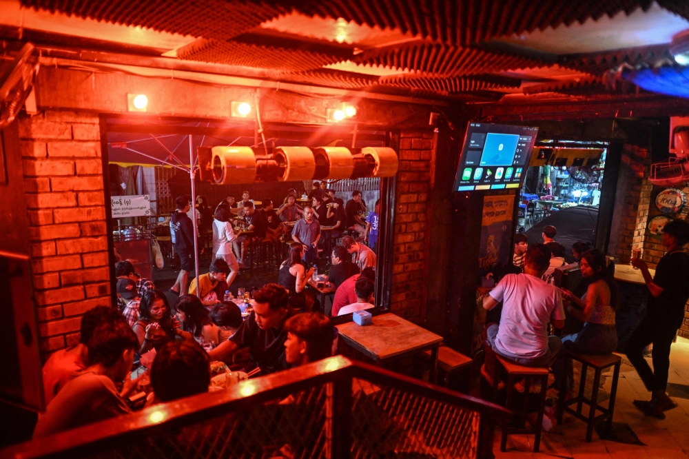 This photo taken on May 15, 2026 shows people having drinks and food outside a restaurant in Yangon. — AFP pic
