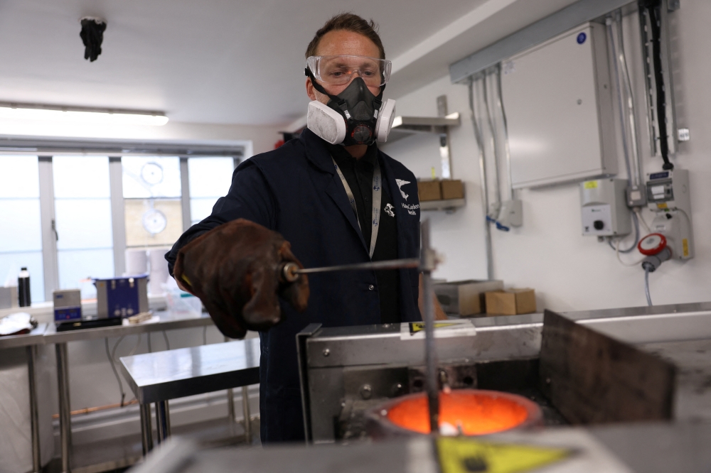 Adam Hole, managing master smelter, stirs molten gold after placing old luxury watches into a furnace at Hatton Garden Metals in London, Britain on June 10, 2026. — Reuters pic