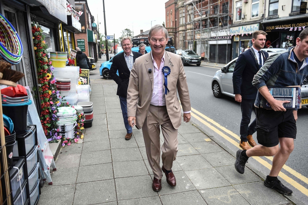 Restore Britain leader Rupert Lowe walks the streets to campaign for the party’s candidate ahead of the Makerfield by-election on June 18, west of Manchester, north-west England on June 13, 2026. — AFP pic