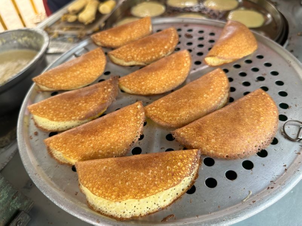 Eaten hot from the pan, the ‘apom’ has a fluffy texture with a rich coconut milk flavour lightly sweetened with the banana. — Picture by Lee Khang Yi