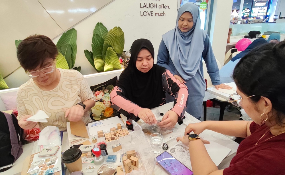 Members of the Malaysia Stamp Hunt Community collect stamps during a gathering of stamp enthusiasts. — Picture courtesy of the Malaysia Stamp Hunt Community