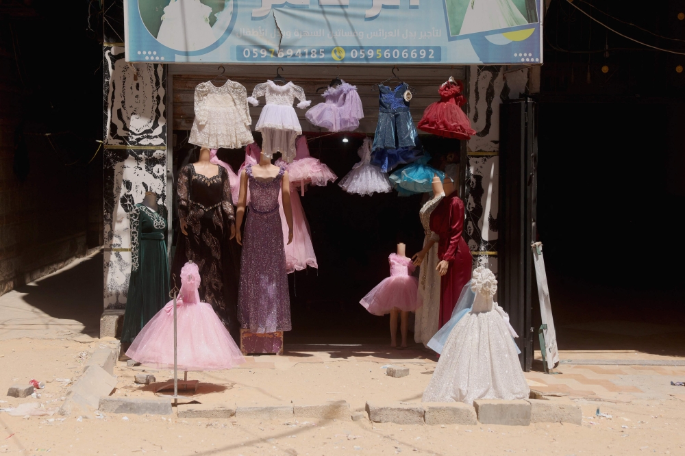Dresses worn for special occasions including weddings are on display outside a shop where they are created despite limited resources and old dresses are recycled, in the city of Khan Yunis in the southern Gaza Strip on June 13, 2026. — AFP pic