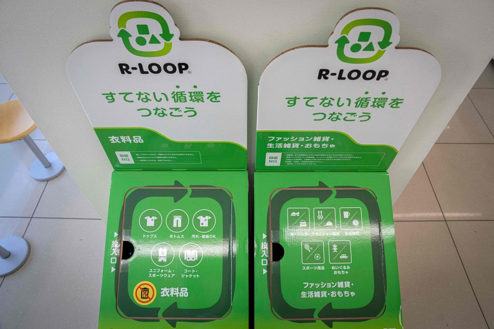 Recycling boxes for clothing, household goods and toys at a FamilyMart convenience store in Tokyo. — AFP pic