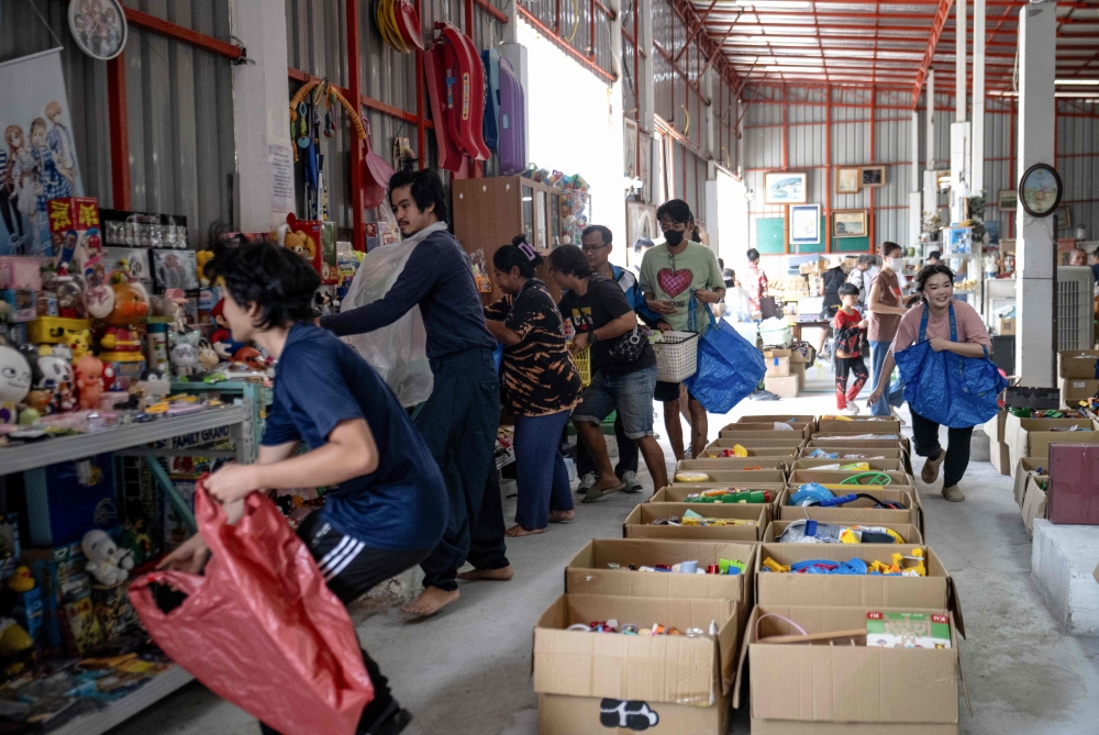 Customers scrambling to collect toys at a Japanese second-hand goods warehouse store in Nonthaburi, Thailand. — AFP pic