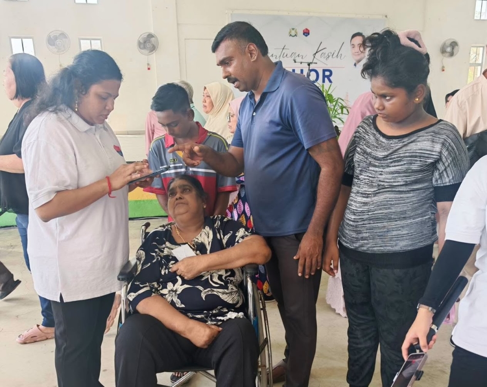 The author interacts with a member of the public during a community outreach programme. — Picture courtesy of Teeba Solaimalai