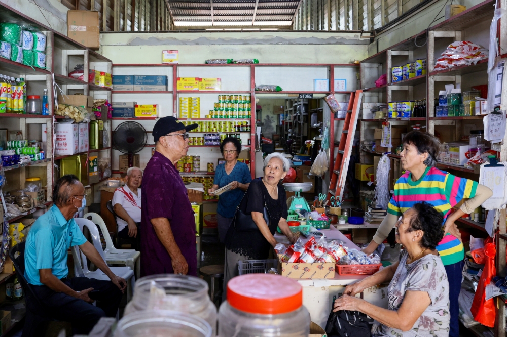 A visit by friends livens up the grocery shop owned by Ma Suat Ngo, 86, (fourth, right) in Kampung Cina, Kuala Terengganu. — Bernama pic