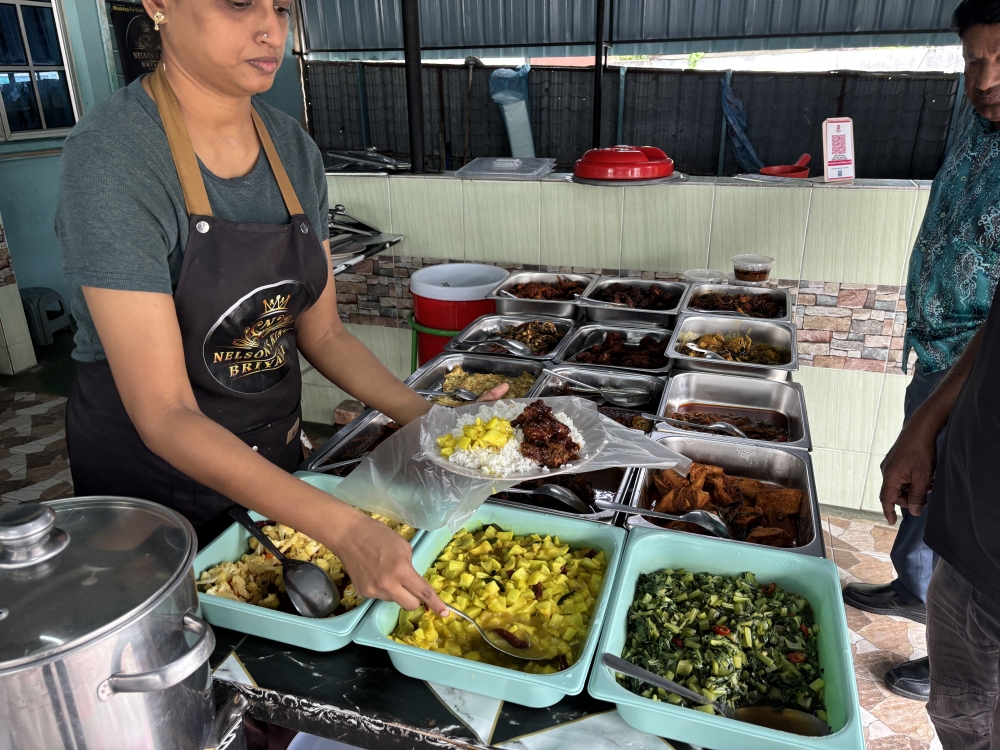 A staff at the Nelson King Briyani in Taman Mas in Ipoh packs a meal for customer. The stall offers RM5 meals for lunch. — Picture by John Bunyan